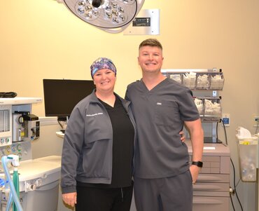 Jessica Busby, CRNA and Timothy Vanderweide, CRNA, NSPM-C standing in an OR room.